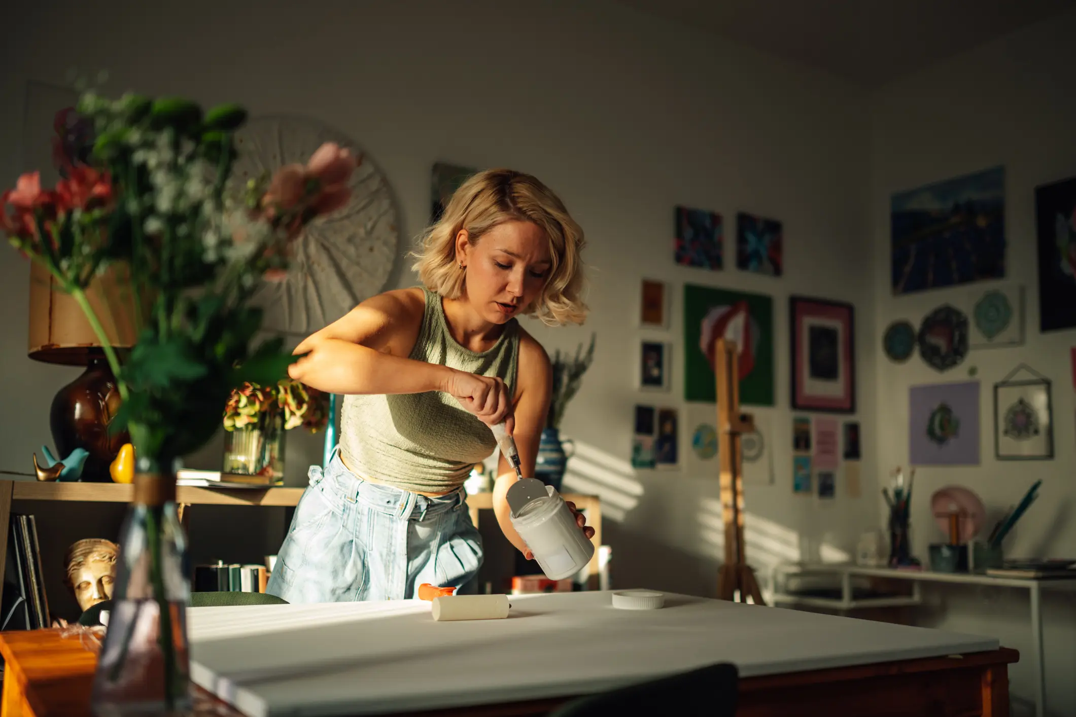 Artist painting in a sunlit studio.